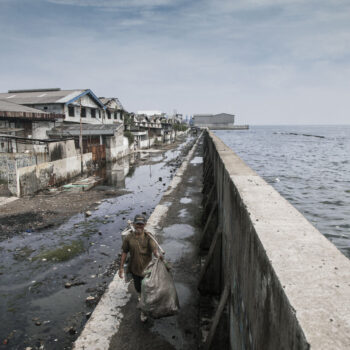 Behind The Wall, A man walking on top of a giant sea wall protecting Jakarta.