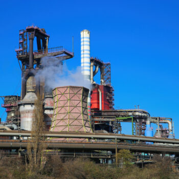 Duisburg (ruhrgebiet), Germany – March 1. 2021: View on industrial complex with smoking chimneys and tower against blue sky – Thyssen Krupp steel company